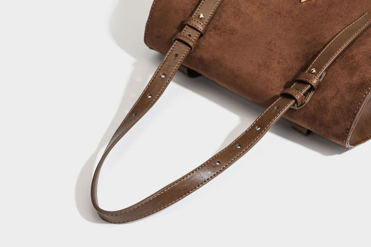 Structured suede-look convertible backpack handbag with flap closure and gold-tone emblem hardware in chocolate brown, detail