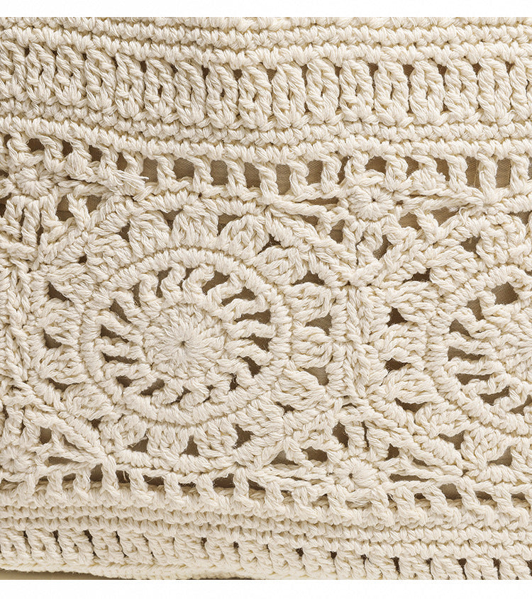 Cream openwork crochet tote bag with tan leather-look double shoulder straps and tassel drawstring tie, detail view 8