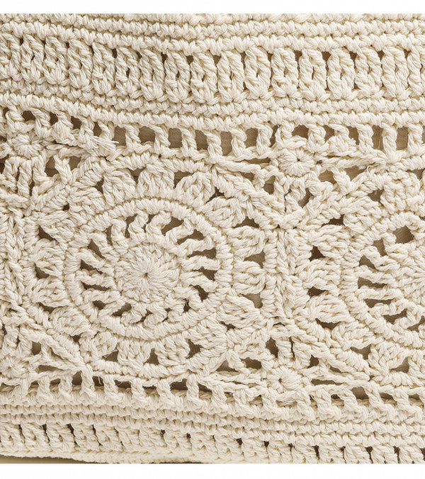 Cream openwork crochet tote bag with tan leather-look double shoulder straps and tassel drawstring tie, detail view 8