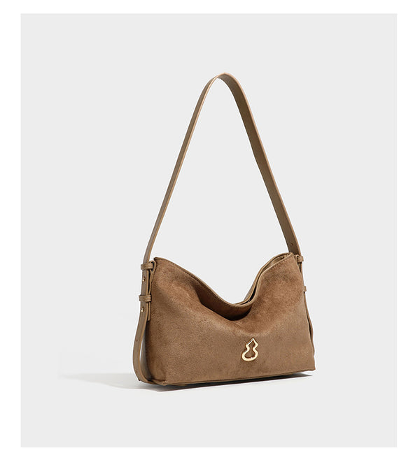 Slouchy suede-finish brown shoulder bag with long single strap and small gold-tone logo emblem on front, detail view 18