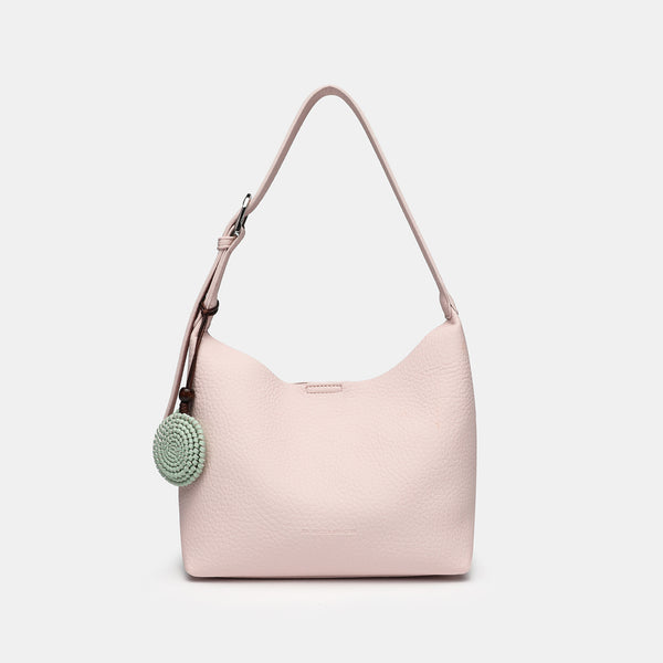 Slouchy hobo shoulder bag in pale yellow pebbled texture with woven charm, adjustable strap, matching zip pouch, and, detail