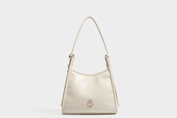 Strukturierte, trapezförmige Schultertasche aus glänzender, geknautscht wirkender Lederoptik mit goldfarbenen Beschlägen auf der Vorderseite und langem, verstellbarem