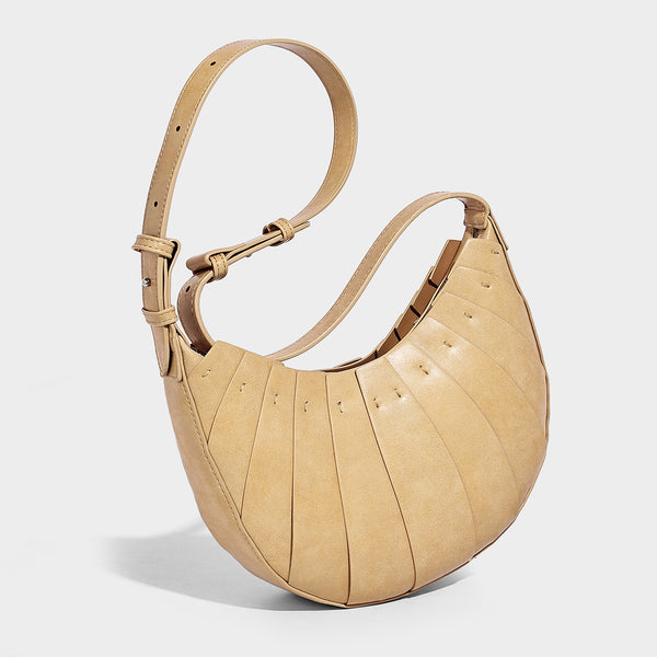 Crescent half-moon shoulder bag with vertical panel seaming, matte-satin leather-look finish, and adjustable gold-tone