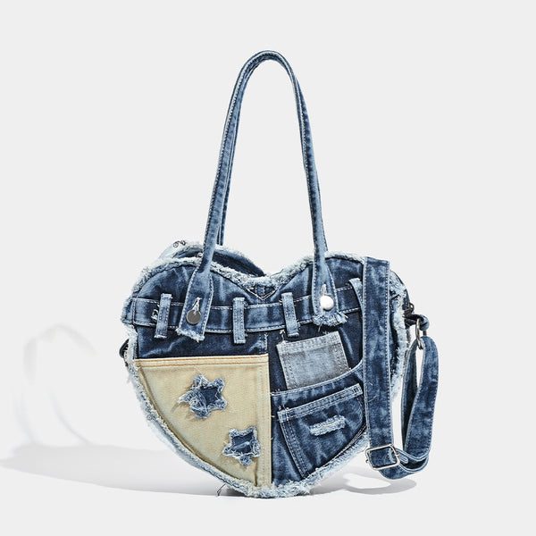 Heart-shaped patchwork washed denim shoulder bag with frayed edges, front patch pockets, and metal hardware, front view