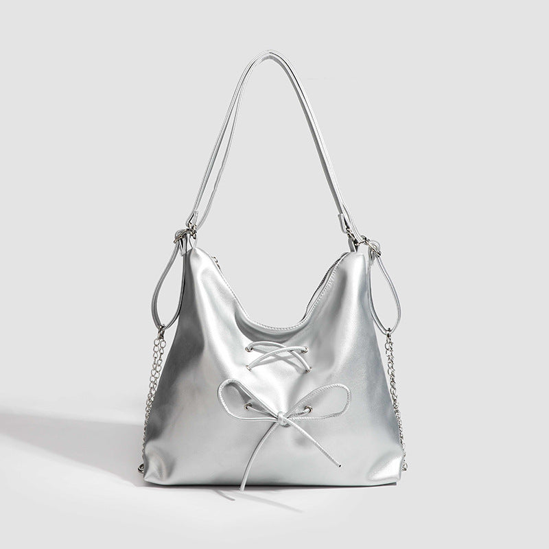 Glossy leather-look hobo shoulder bag with front bow lacing detail and silver-tone chain strap, detail view 8