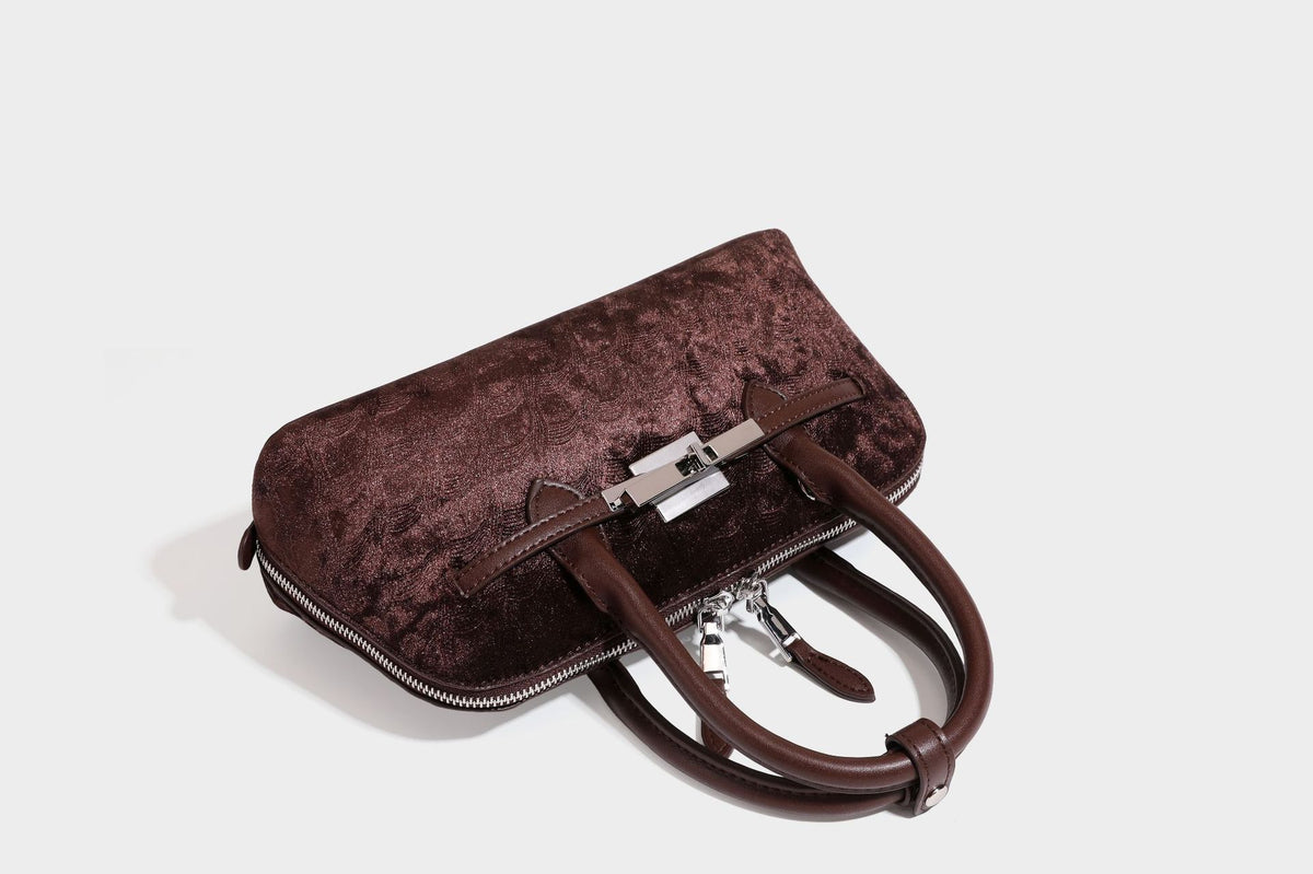 Small structured satchel bag in dark brown velvet-like textured finish with leather-look trim, silver-tone turn-lock bar