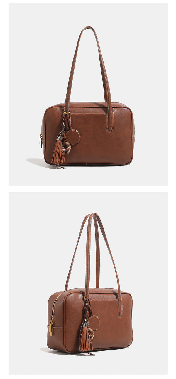 Structured rectangular leather-look shoulder bag with top zip, tassel and resin ring charm, and contrast topstitching, detail