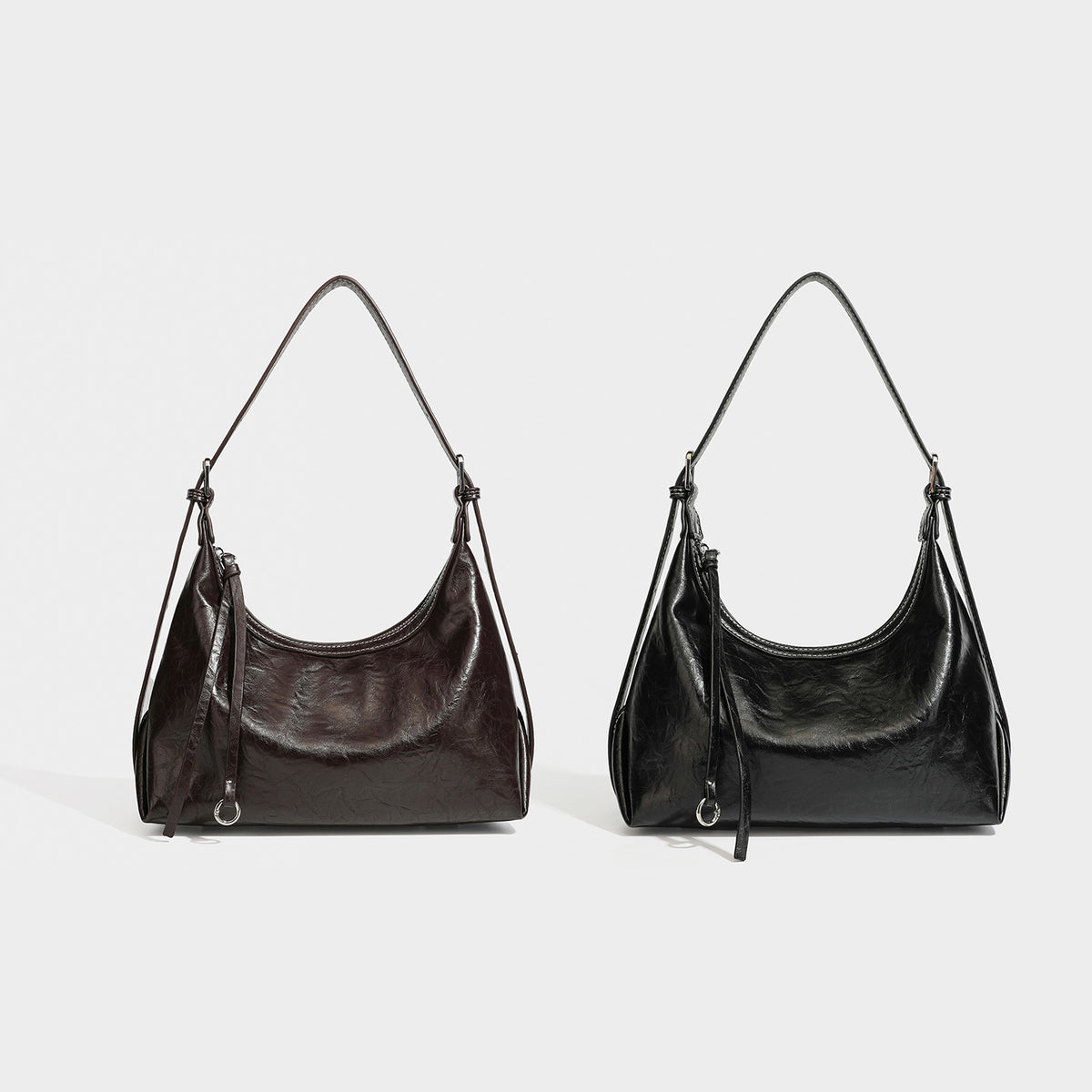 Slouchy hobo shoulder bag in glossy crinkled leather-look finish with zip-top closure and silver-tone ring hardware, detail