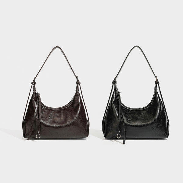 Slouchy hobo shoulder bag in glossy crinkled leather-look finish with zip-top closure and silver-tone ring hardware, detail