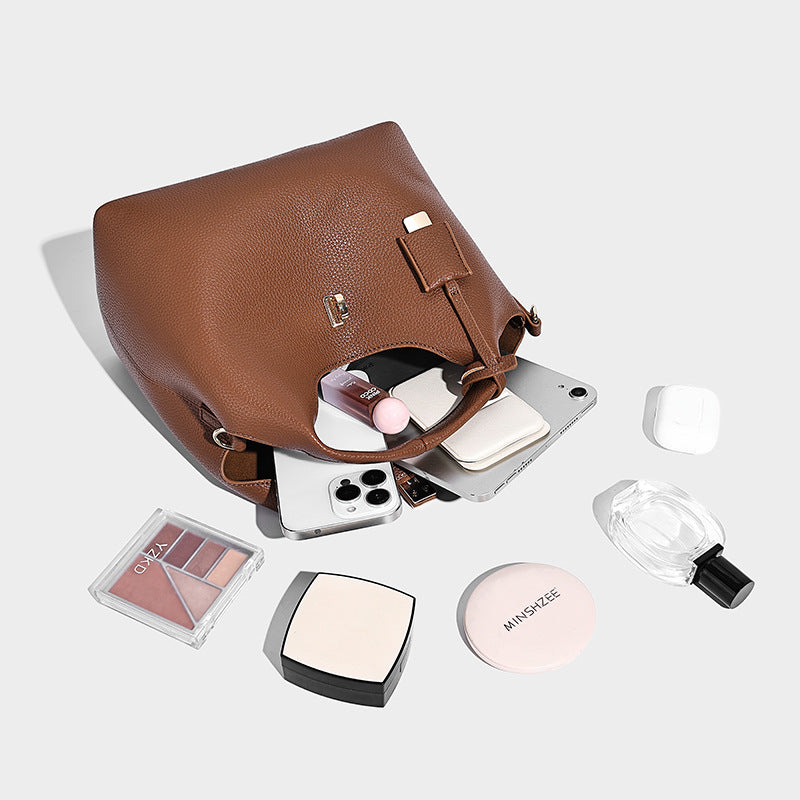 Structured pebbled-texture bucket bag with arched top handles, gold-tone turn-lock closure, and detachable shoulder strap