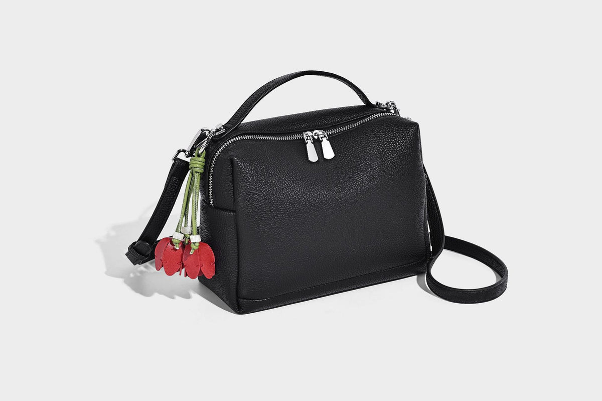 Kleine strukturierte Crossbody-Tasche mit Tragegriff aus genarbtem Material, Reißverschluss, silberfarbenen Beschlägen und optionalem Quastenanhänger