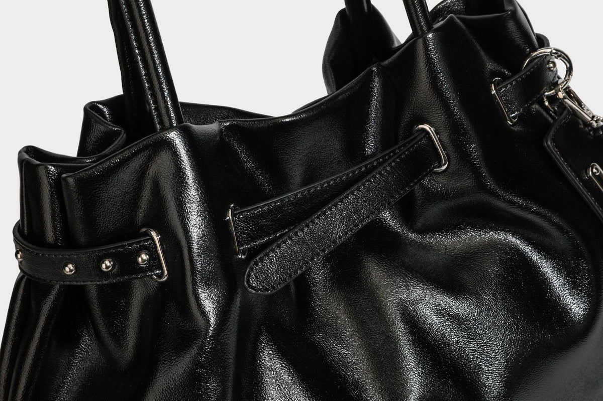 Glänzende schwarze, weich fallende Schultertasche mit gerafftem Abschluss, zwei langen Trageriemen, silberfarbenen Beschlägen und abnehmbarem Umhängeriemen