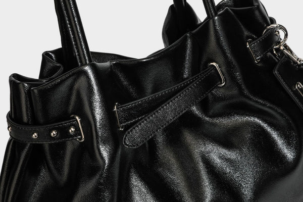 Glänzende schwarze, weich fallende Schultertasche mit gerafftem Abschluss, zwei langen Trageriemen, silberfarbenen Beschlägen und abnehmbarem Umhängeriemen