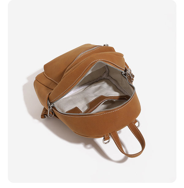 Mini-Rucksack-Handtasche mit abgerundeter Form und genarbter Oberfläche, silberfarbenen Beschlägen, Reißverschlussfach auf der Vorderseite und verstellbaren Trägern zum Umwandeln