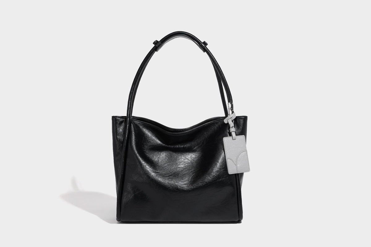 Glänzende Tote-Bag in schwarzer Lederoptik mit zwei runden Tragegriffen und silberfarbenen Beschlägen, Detailansicht 13