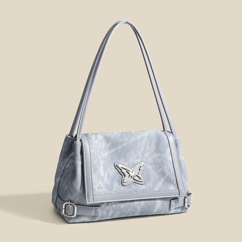 Washed leather-look shoulder tote bag with silver butterfly emblem and buckle hardware, detail view 3