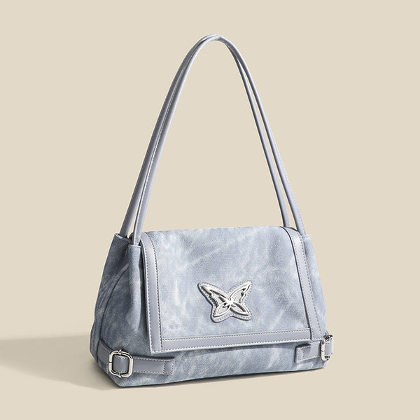Washed leather-look shoulder tote bag with silver butterfly emblem and buckle hardware, detail view 3