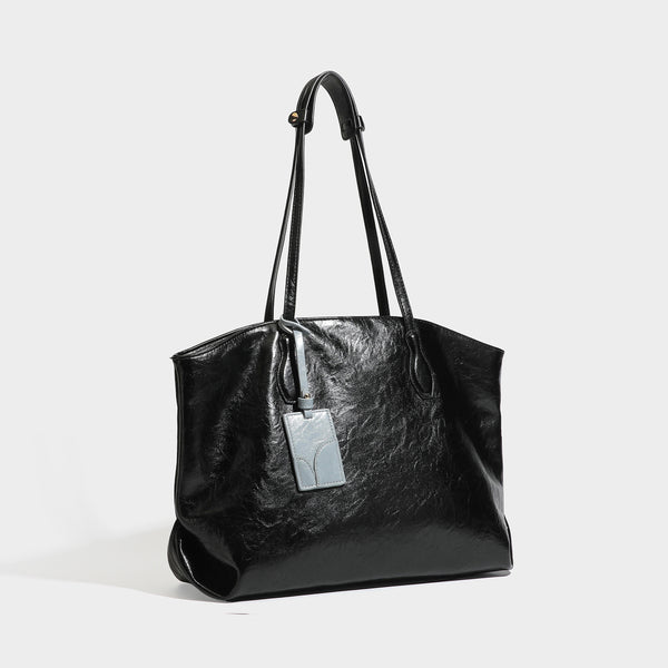 Oversized-Shopper mit lässig-weicher Form in dunkler Burgunderfarbe, glänzender geknautschter Lederoptik, zwei langen Schulterriemen und kontrastierendem