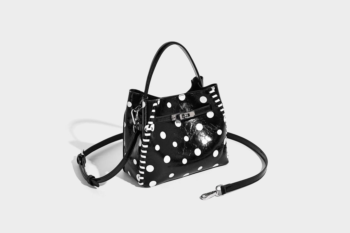 Glänzende, geknautschte Beuteltasche mit Polka-Dots, silberfarbenen Schnallenbeschlägen, kontrastierendem seitlichem Schnürbesatz, Tragegriff und abnehmbarem