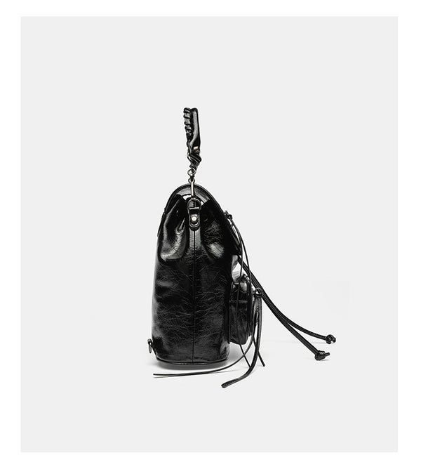 Small structured glossy leather-look convertible backpack handbag in black with flap closure, front zip pockets, metal stud