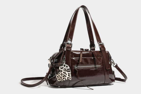 Strukturierte Schultertasche aus glänzendem Lederimitat mit abgerundetem Korpus, silberfarbenen Metalldetails, Reißverschlussfach vorne und Leopardenmuster