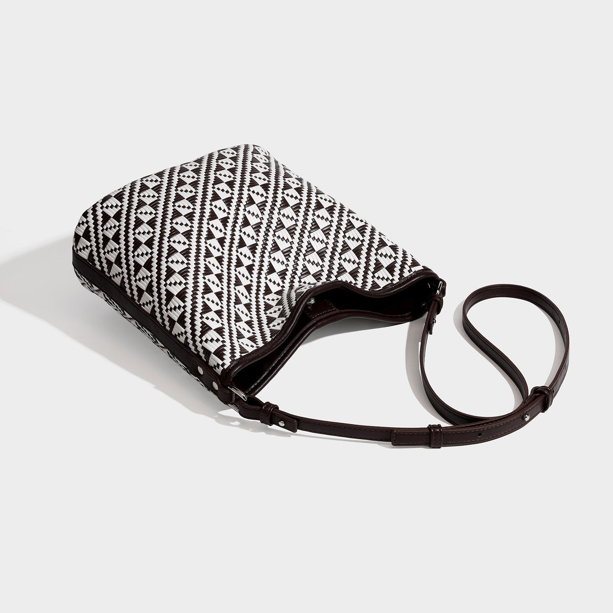 Geometrisch gemusterte Schultertasche mit gewebtem Ethno-Muster, dunkelbrauner Lederoptik-Besatzung, langem verstellbarem Riemen und kleinem herabhängendem Reißverschluss