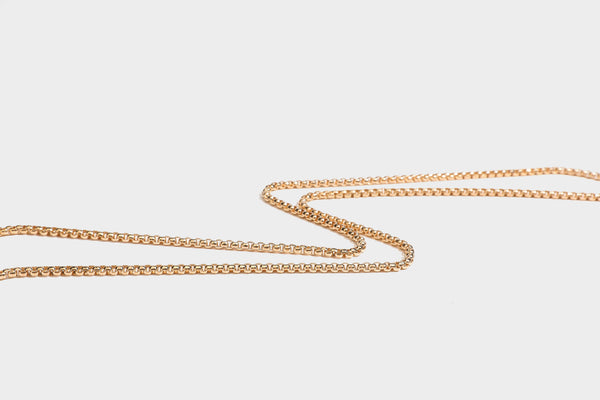 Strukturierte rechteckige Clutch mit goldfarbenem Henkel in Form einer Rosenknospe und abnehmbarem Kettenriemen in Metallic-Optik, Detailansicht