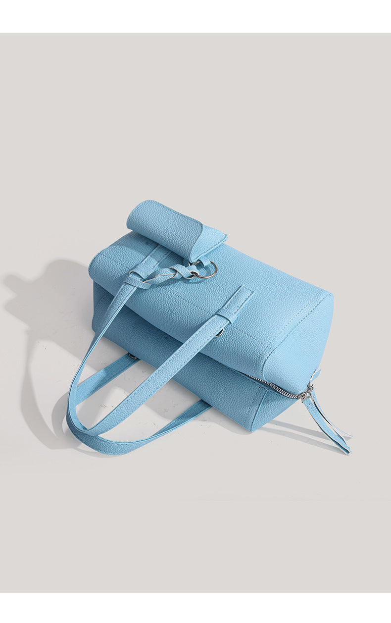 Light blue pebbled matte Boston tote bag with top handles, detachable shoulder strap, metal ring hardware, and matching mini