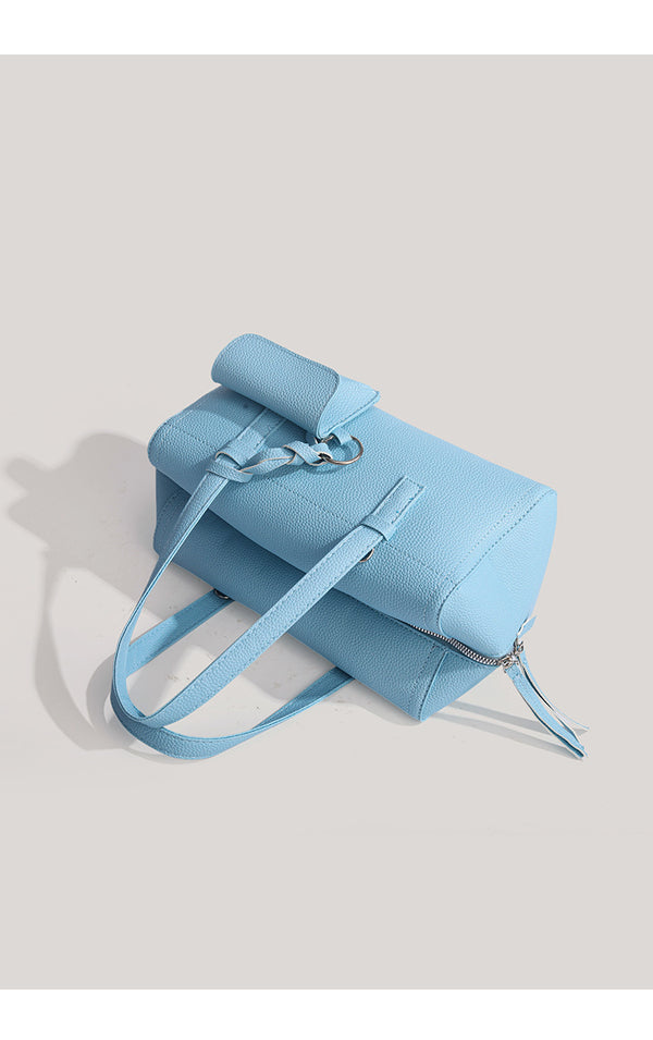 Light blue pebbled matte Boston tote bag with top handles, detachable shoulder strap, metal ring hardware, and matching mini