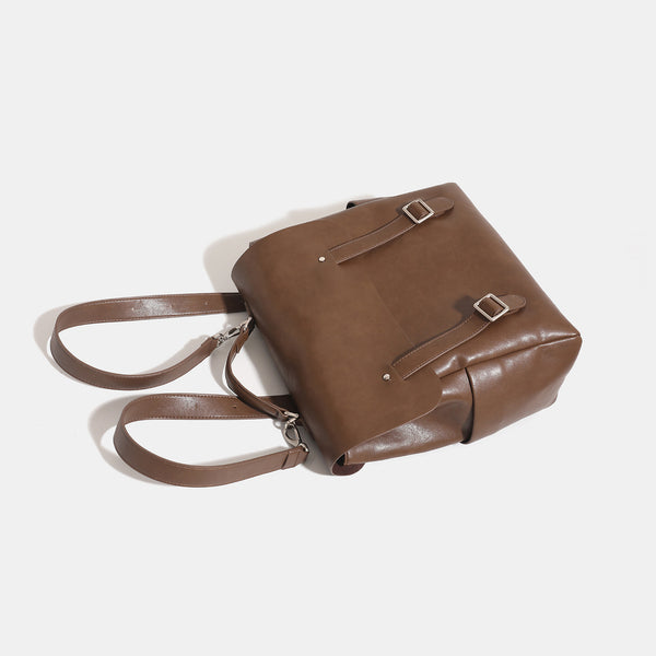 Structured flap backpack handbag in smooth leather-look finish with buckle front pocket, top handle, and silver-tone