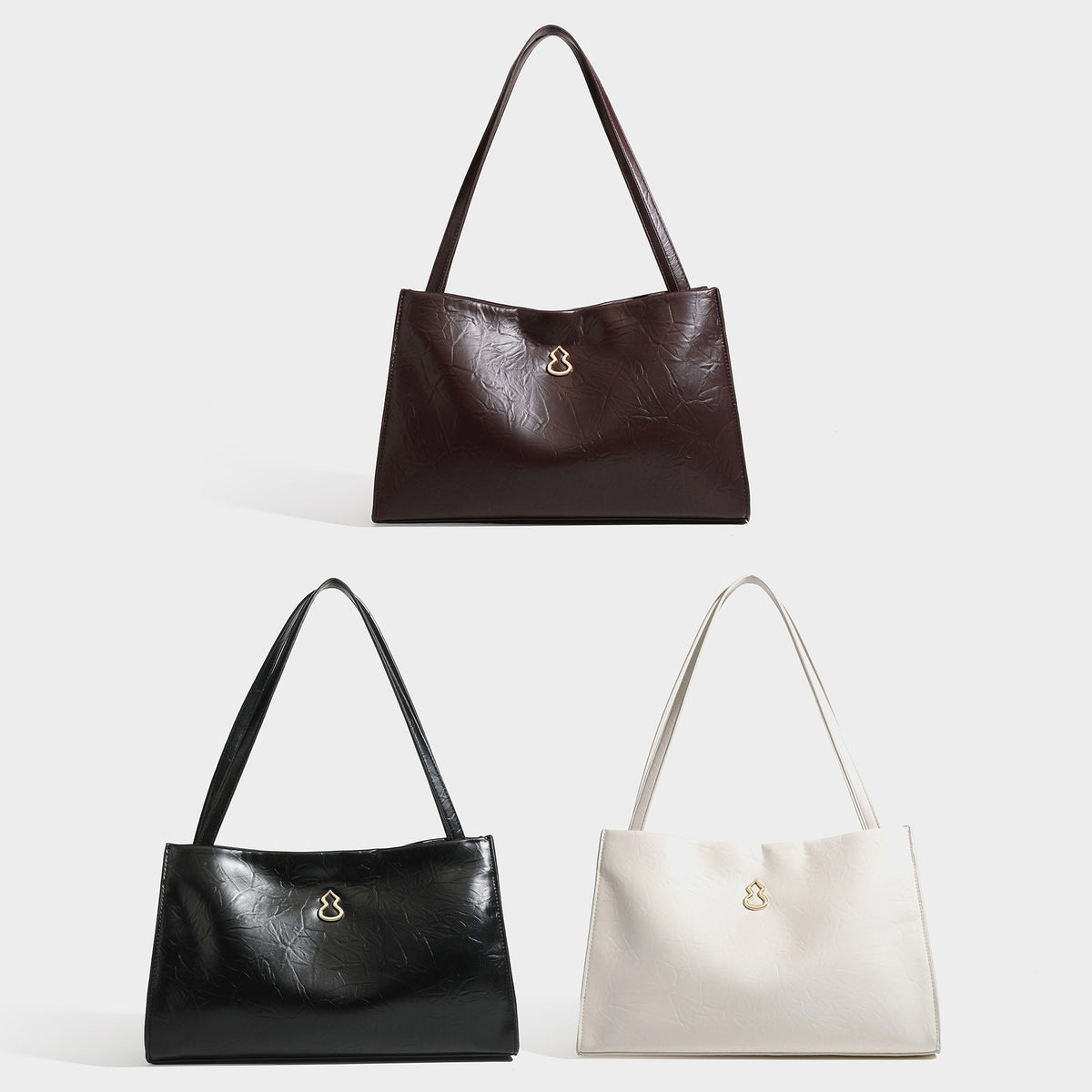 Strukturierte rechteckige Schultertasche im Tote-Stil mit glänzender, geknautschter Oberfläche in Lederoptik, langen Doppelriemen und Emblem in Goldoptik