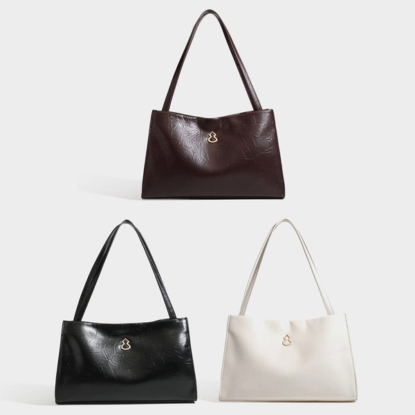 Strukturierte rechteckige Schultertasche im Tote-Stil mit glänzender, geknautschter Oberfläche in Lederoptik, langen Doppelriemen und Emblem in Goldoptik