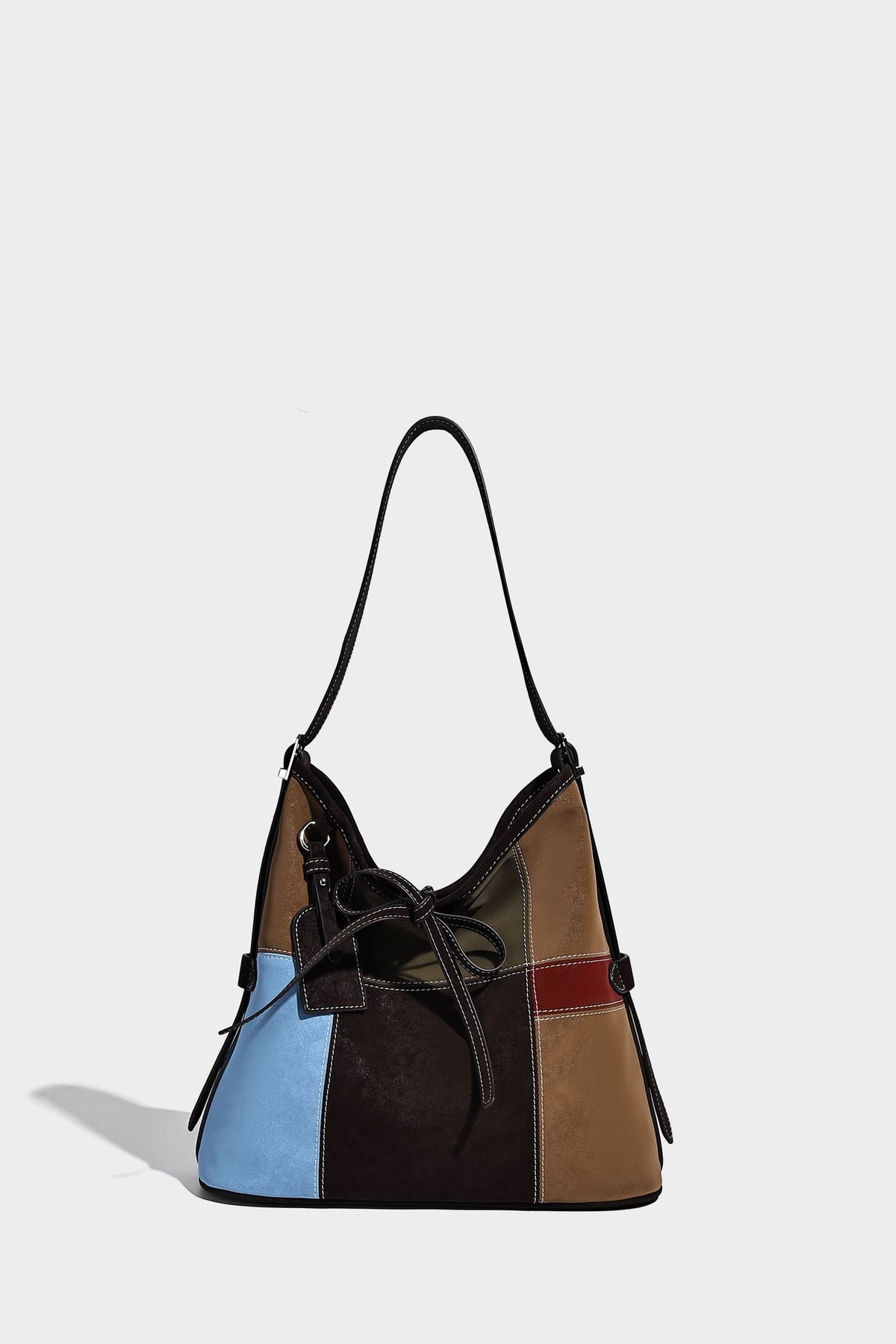 Patchwork bucket tote shoulder bag with tan, dark brown, olive, red, and sky blue color-block panels, white contrast, detail