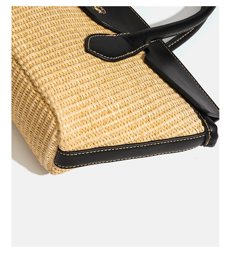 Structured tan woven straw tote bag with black leather-look trim, twin rounded top handles, gold-tone turn-lock front flap