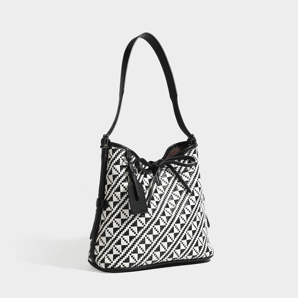Woven geometric bucket shoulder bag in white and dark brown two-tone pattern with leather-look trim and drawstring top, front