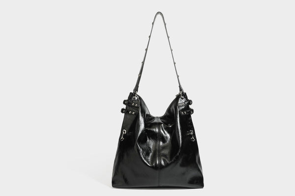 Black glossy leather-look slouchy shoulder bag with silver stud and eyelet hardware, top zip closure, front zip pocket, and