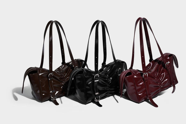 Glänzende, rechteckige Schultertasche mit Raffdetails, zwei verstellbaren Riemen, Reißverschluss oben und Schnallenbeschlägen in Silberoptik