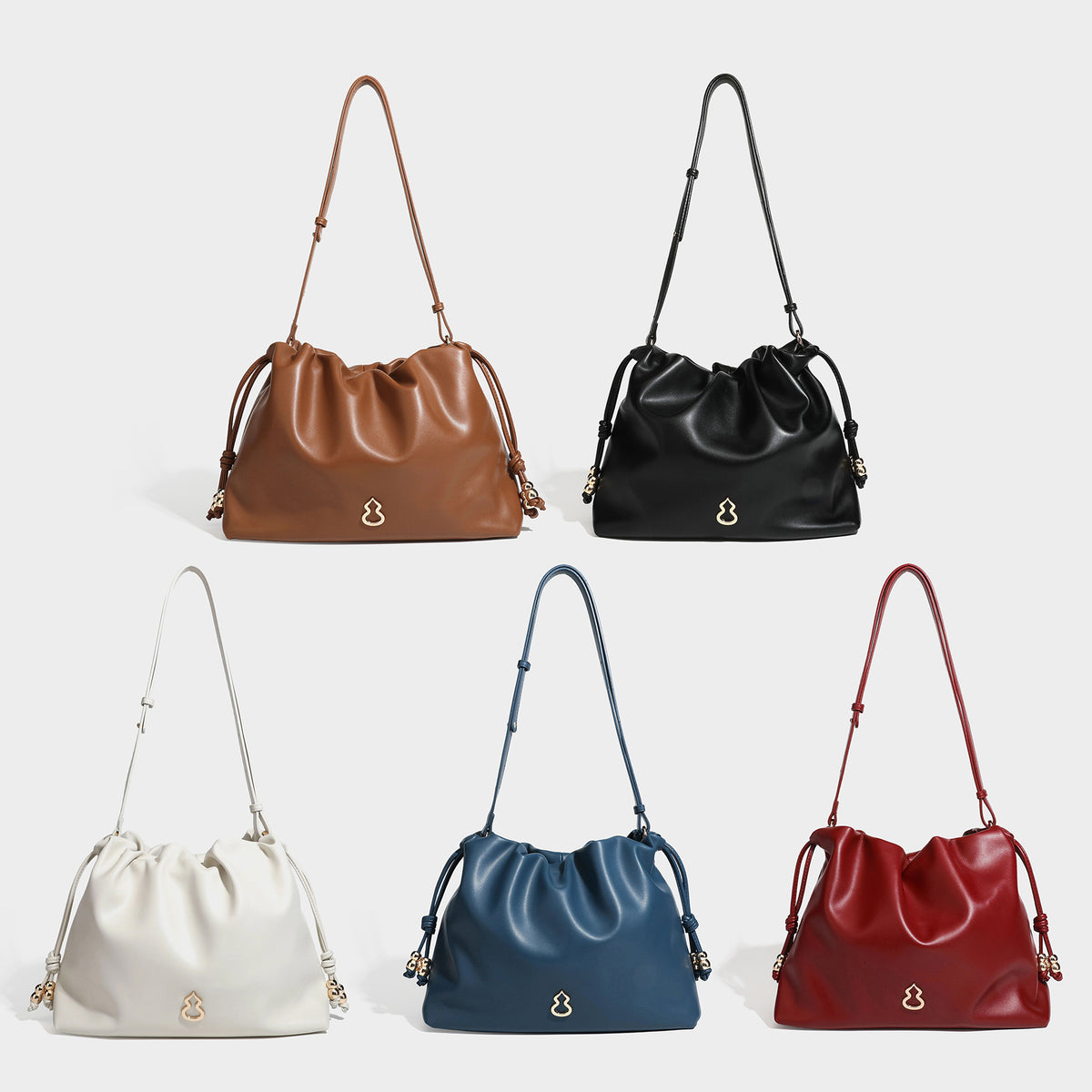 Slouchy ruched drawstring shoulder bag in smooth leather-look finish with gold-tone emblem and slim adjustable strap, detail