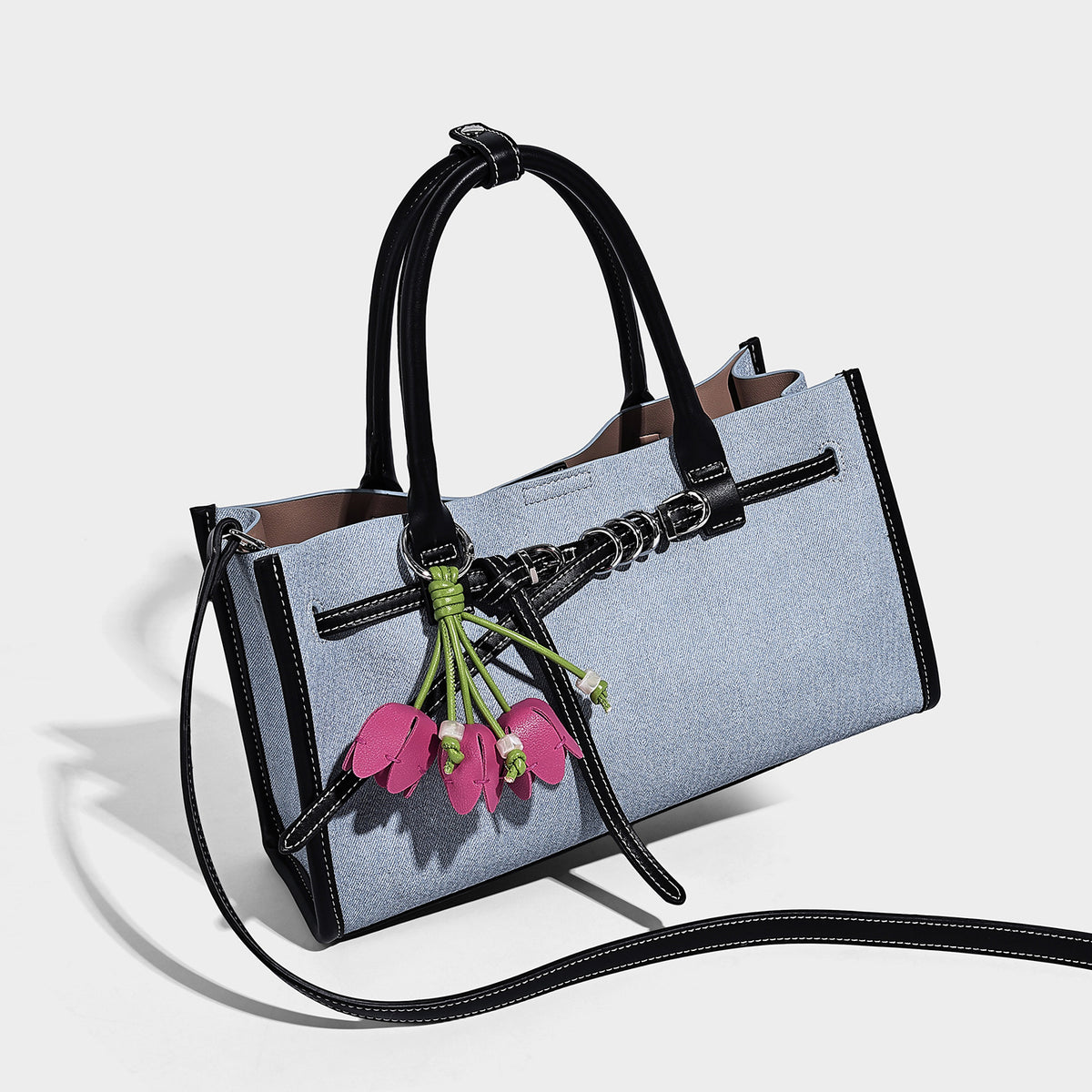 Structured rectangular tote satchel in denim-look fabric with dark trim, knotted front strap hardware, and detachable, front