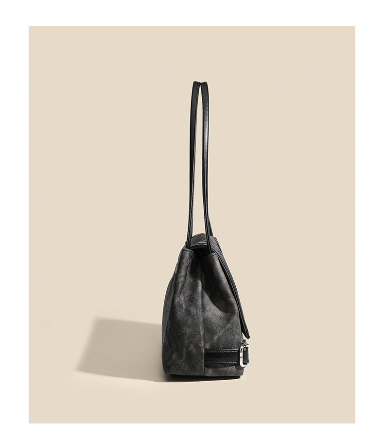 Washed leather-look shoulder tote bag with silver butterfly emblem and buckle hardware, detail view 9