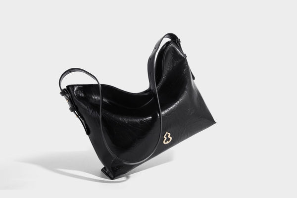 Large slouchy hobo shoulder bag in glossy crinkle leather-look finish with gold-tone emblem hardware and adjustable strap