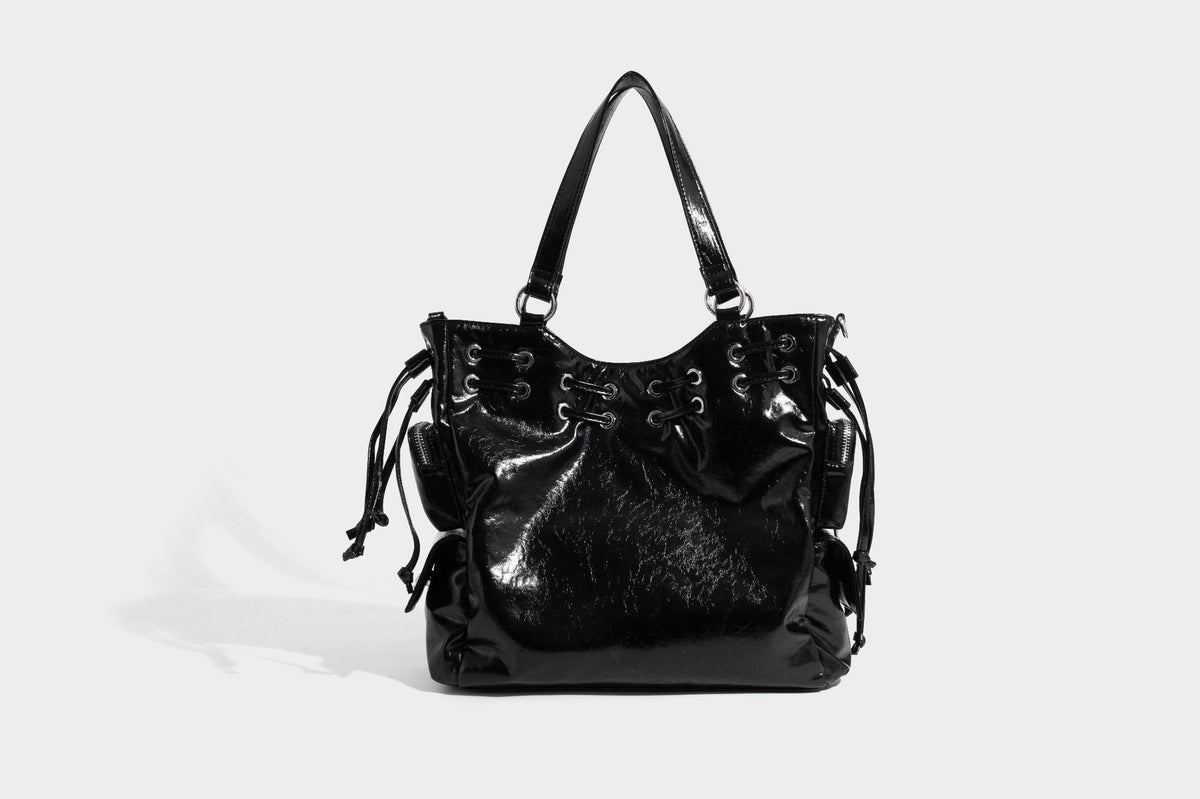 Glossy crinkled leather-look tote bag with silver grommet lace-up front detail, dual top handles, and detachable shoulder