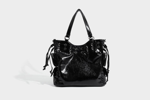 Glossy crinkled leather-look tote bag with silver grommet lace-up front detail, dual top handles, and detachable shoulder