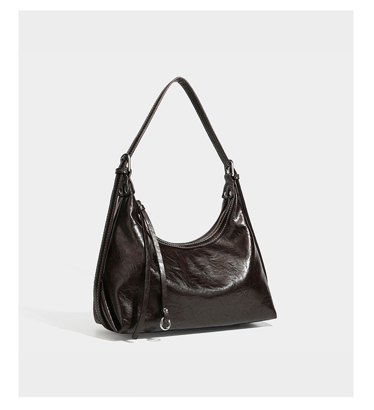 Slouchy hobo shoulder bag in glossy crinkled leather-look finish with zip-top closure and silver-tone ring hardware, detail