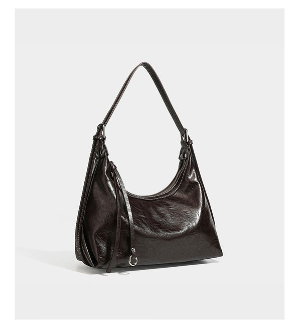 Slouchy hobo shoulder bag in glossy crinkled leather-look finish with zip-top closure and silver-tone ring hardware, detail