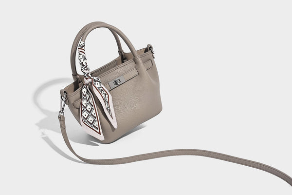 Kleine strukturierte Henkeltasche aus genarbtem Material in Taupe mit zwei Henkeln, bedrucktem Schalband, vorderem Drehverschluss und, Detail