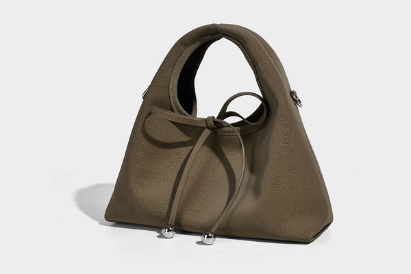 Pebbled matte trapezoid top-handle bag with drawstring bow closure, bead-tipped cords, silver-tone hardware, and detachable