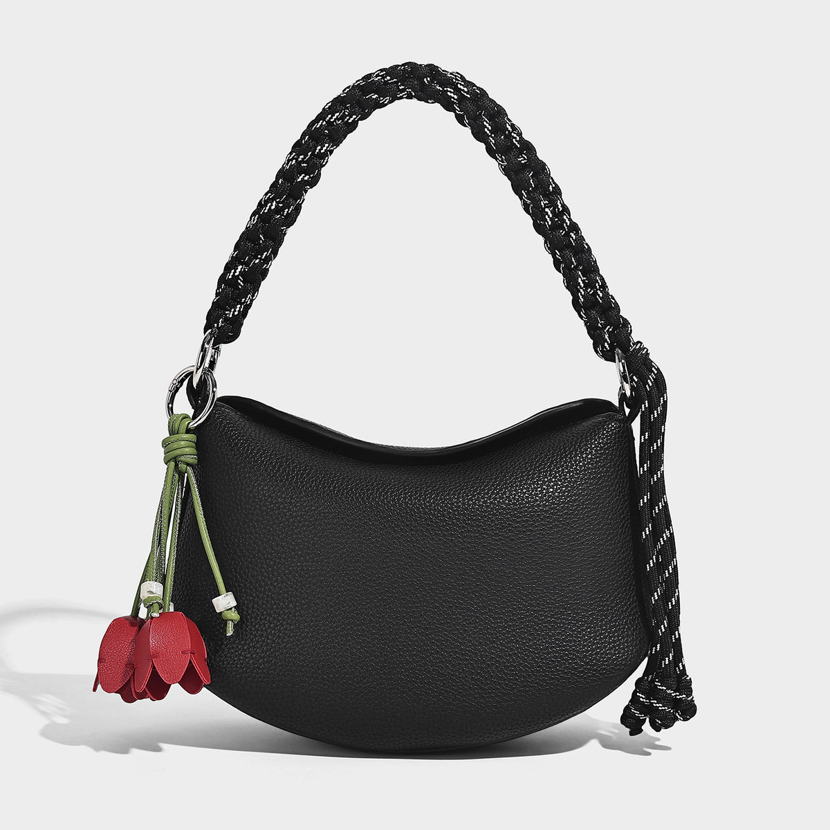 Small crescent half-moon bag in pebbled leather-look finish with braided top handle, silver-tone ring hardware, and, detail