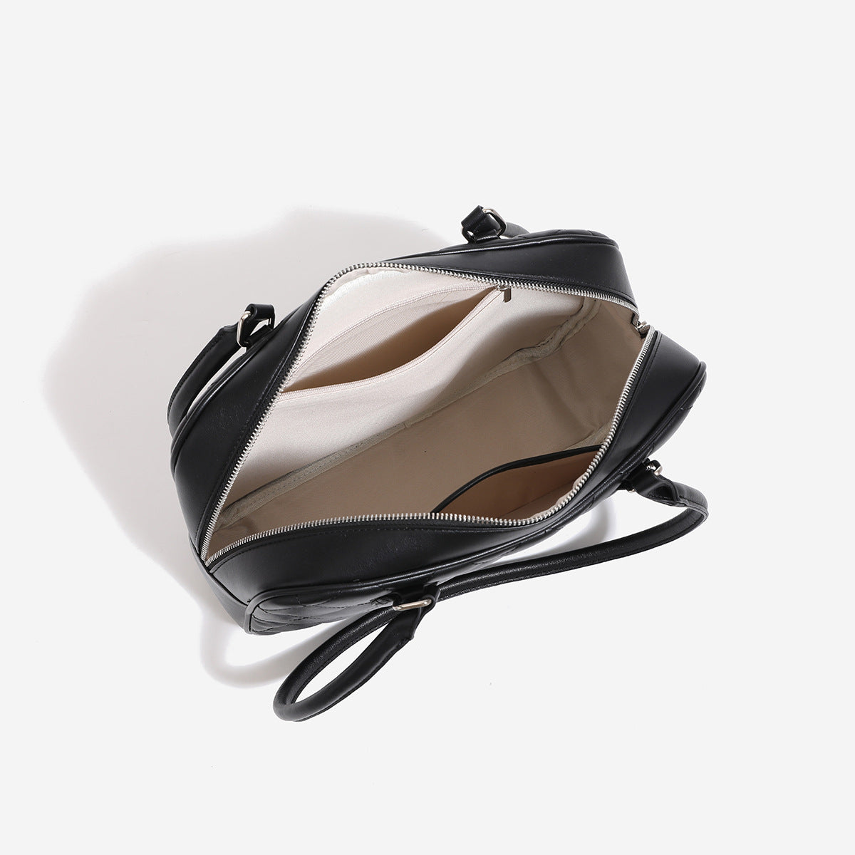 Strukturierte, rautenförmig gesteppte Bowling-Schultertasche mit glänzender Lederoptik, Reißverschluss oben und silberfarbenem