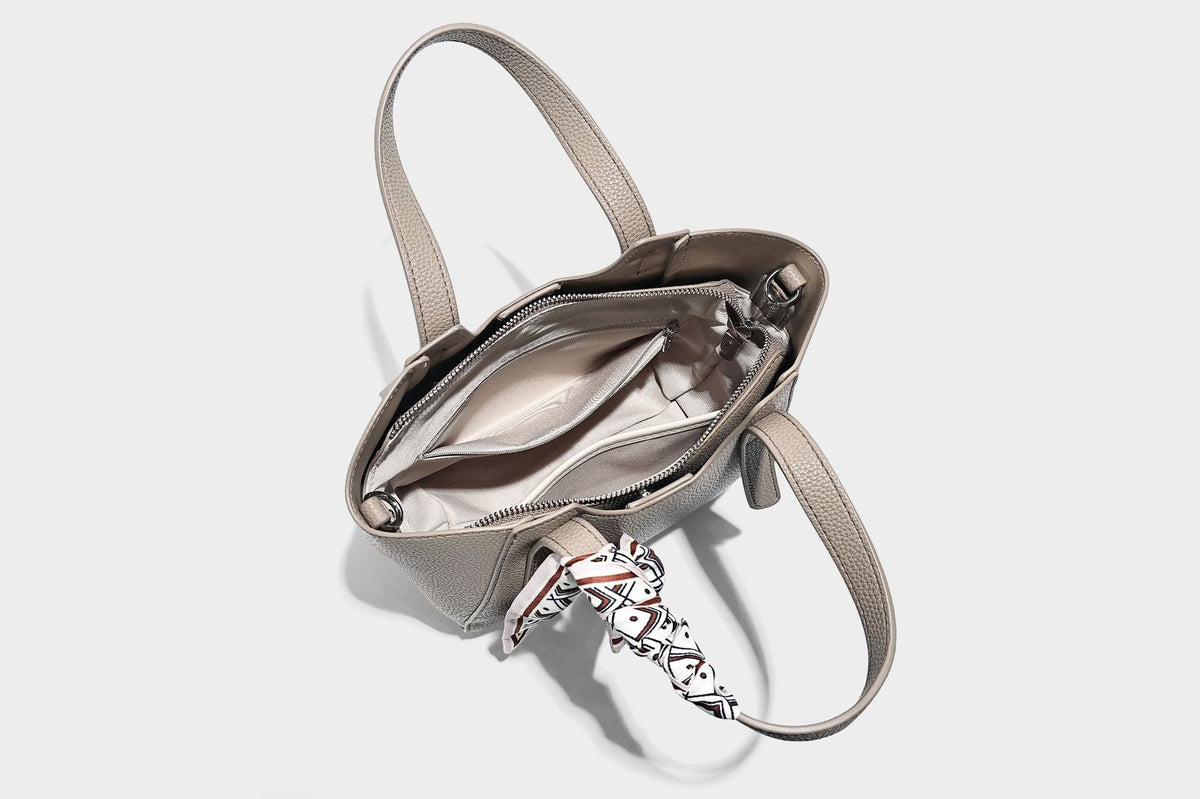 Structured pebbled leather-look tote bag with detachable scarf tie, dual top handles, and adjustable crossbody strap, detail